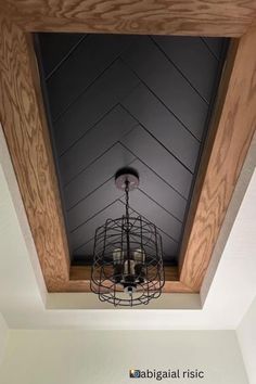 the light fixture is hanging from the ceiling in the room with wood paneling on the walls