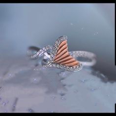 a diamond ring with an orange and white stripe on the side, in front of a blue background