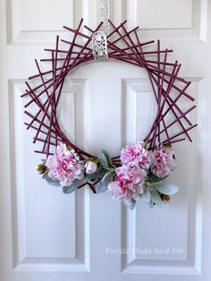 a purple wreath with pink flowers on the front door