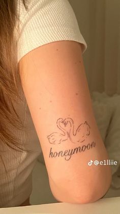 a woman with a tattoo on her arm that says honey moon and two swans in the middle