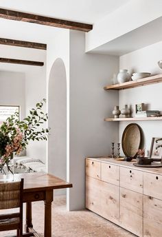 a dining room table and some shelves with vases