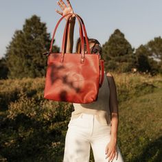 "Our Mid-sized Zipper Tote carries it all without sacrificing size. Not too small, not too big - this bag will hold all of your essentials, plus more! It features a top zipper closure and crossbody strap to go hands-free. This full-grain leather bag is a closet staple and will be a go-to for years to come. * 13\" wide, 12\" tall, 2\" deep * 1 crossbody strap - adjustable and removable * Top zipper closure * Fully-lined inside * 2 open pockets and 1 zipper pocket inside * Fits a 13\" laptop * Ful Satchel With Removable Pouch For Everyday Use, Large Bags With Detachable Handle For Daily Use, Daily Use Satchel With Top Carry Handle, Large Bags For Errands, Large Satchel With Detachable Handle, Large Shoulder Bag With Detachable Handle For Travel, Large Everyday Bags With Detachable Handle, Top Handle Shoulder Bag For Everyday Use, Large Everyday Bag With Detachable Handle