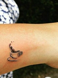 a small coffee cup tattoo on the arm