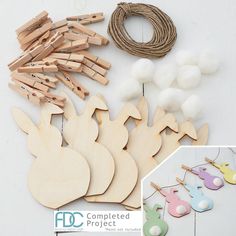 various wooden toys are displayed on a table with string and cotton balls in the background