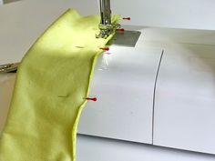 a close up of a sewing machine with a bright yellow cloth on it's side