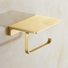 a wall mounted shelf with a metal hook on it