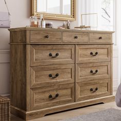 a wooden dresser with drawers and mirrors in a room