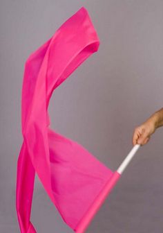 a woman holding an umbrella in her right hand and wearing a pink dress on the left