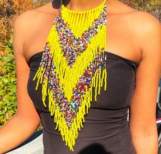 Eye-catching design: Exaggerated tassel bib necklace with African beaded detail Versatile accessory: Perfect for adding a pop of color and texture to any outfit High-quality material: Made with durable acrylic beads and braided cord for long-lasting wear Statement piece: Makes a bold statement and adds personality to any look Handmade craftsmanship: Each necklace is carefully crafted by one skilled artisan for a unique touch Bohemian Beads For Summer Party, Bohemian Party Beads For Summer, Multicolor Beaded Tassel Necklace For Festivals, Festival Tassel Fringe Necklace, Beaded Tassel Necklace For Festivals, Bohemian Fringe Tassel Necklace For Parties, Multicolor Fringe Necklace For Festival, Bohemian Bib Necklaces With Dangling Beads For Party, Bohemian Party Bib Necklaces With Dangling Beads