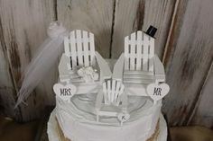 a wedding cake with two chairs on top and the words mr and mrs written on it