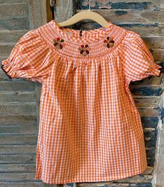 Adorable Thanksgiving smock dress. 100% cotton. Machine wash, lay flat to dry. Fits true to size. Please refer to size chart in item's pictures. :) Our smocks are made by a trusted partner within the USA. Ships within 1-3 business days.  Arrives 1-5 business days after shipped. If need it sooner, please message us, and I can send you an upgrade for shipping. Short Sleeve Gingham Smock Dress, Cotton Smocked Beach Tops, Beach Cotton Smock Tops, Cotton Smock Top For The Beach, Fall Cotton Smocked Dress, Fall Cotton Smocked Back Dress, Cotton Gingham Smocked Dress With Ruffles, Fall Cotton Dresses With Smocked Back, Cotton Smocked Dress With Ruffles In Gingham