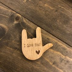 a wooden brooch that says i love you with a heart in the shape of a hand