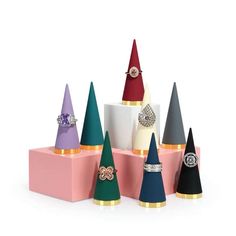 several different colored cones with rings on them and one has a diamond ring in the middle