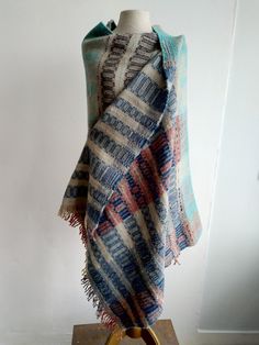 a multicolored shawl draped over a mannequin