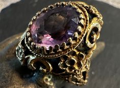 "A 14k Amethyst vintage ring.  condition I see no problems, it appears to have never been worn, photos show the details.  Size 7 2/3, wet.- 9.3 grams(solidly made), almost 1\" north to south on finger.  The design has a Victorian feel to it although I believe it is from the mid 1900s.  Lots of interesting design, fancy bezel set 13 by 10mm Amethyst, medium shade of color, no wear to stone.  Stamped 14K." Vintage Purple Sapphire Gemstone Ring, Luxury Collectible Amethyst Ring, Antique 14k Stamped Amethyst Ring, Antique Oval Amethyst Ring For Anniversary, Antique Oval Amethyst Anniversary Ring, Heirloom Amethyst Ring Stamped 14k, Heirloom Amethyst Rings With Intricate Design, Collectible Amethyst Ring, Formal Vintage Amethyst Ring