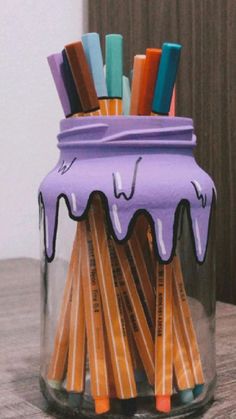 a jar filled with pencils sitting on top of a table