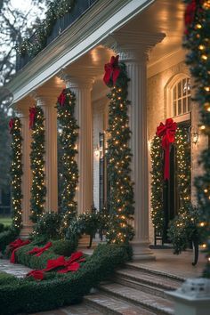 christmas decorations on the front porch of a house with lights and wreaths around it