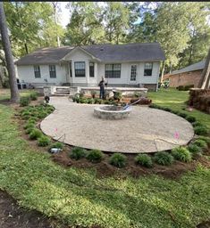 a backyard with a fire pit surrounded by grass