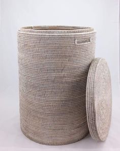 a large woven basket next to a round object on a white tablecloth covered surface