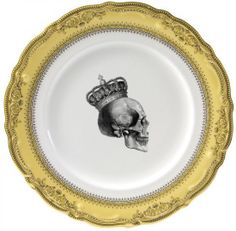 a gold and white plate with a skull wearing a crown