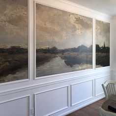 three paintings are hanging on the wall above a dining room table