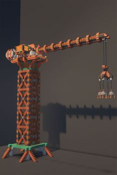 an orange and green tower crane next to a gray wall