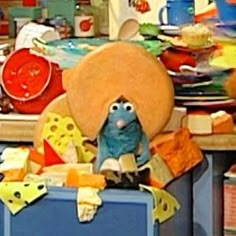 a blue bird sitting on top of a piece of luggage in front of a pile of dishes