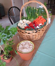 a table with carrots, celery, and other vegetables in a basket