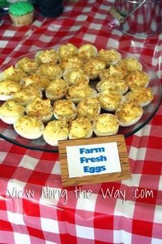 a table topped with lots of food on top of a red and white checkered table cloth