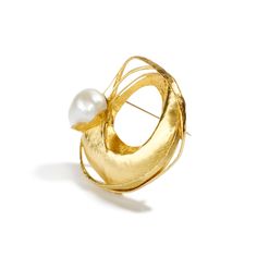 24K & 18K yellow gold, 18mm South Sea Pearl This magnificent South Sea Pearl is held in the folds of high karat gold, as if waves of the precious metal are slowly rocking amongst their lustrous frame to reveal the gift of the sea; a hidden gem from the crevasses of the ocean depths. Playing with form and space, its masterful maker, Alexandra Watkins brilliantly coaxes the gold to satisfy her wondrous imagination. The pearl's enduring opalescence beckons one's gaze as the onlooker remains entranc Gold Evening Brooch Jewelry, Formal Fine Jewelry Gold Brooches, Unique Yellow Gold Brooches For Gifts, Gold Round Brooches For Gifts, Elegant Gold Brooch Jewelry, Elegant Yellow Gold Brooch Gift, Elegant Yellow Gold Brooches As Gift, Gold Wedding Brooches, Exquisite Yellow Gold Brooch For Anniversary