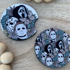 two plates decorated with skulls and flowers on top of a wooden table next to balls