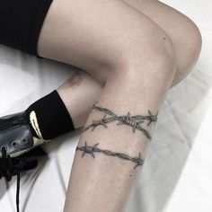 a woman's legs with barbed wire on them