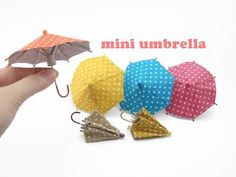 small umbrellas with polka dots on them are being held by a person's hand