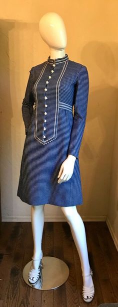 This is a Darling vintage 1970'S dress by Narciso Rodrigues.  It is a heavy woven cotton blend fabric in a blue & white check. It has the white ball buttons and white ribbon trim. Note dress is short waisted so keep in mind for measurements.  Great dress for office, church or to run errands about town. It is in good condition.    As with all vintage please go by measurements below comparing to something in your wardrobe with a good fit. Measurements Lying Flat:  Bust 17”, Empire Waist 14”, Hips Blue Knee-length Vintage Dress For Vintage Fashion, Vintage Blue A-line Dress, Fitted Vintage Blue Vintage Dress, Blue Fitted Vintage Dress, Formal Long Sleeve Blue Vintage Dress, Formal Blue Long Sleeve Vintage Dress, Blue Retro Dress With Vintage Print, Mid-century Long Sleeve Fitted Dress, Retro Long Sleeve Dresses With Buttons