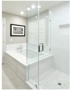 a white bathroom with a glass shower door