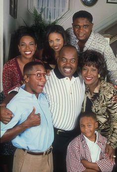 a group of people standing next to each other in front of a stair case with one man giving the thumbs up