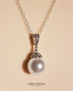 Wedding Swarovski 10mm White Pearl Drop 925 Sterling Silver Chain CZ Bridal Necklace. Classy and elegant, this necklace would be great for any wedding! CHAIN is 18 inches (45.7 cm) long. PENDANT is about 0.86 inch (2.2cm) long including bail. MATCHING EARRINGS: https://www.etsy.com/listing/99757178/bridal-white-drop-pearl-earrings?ref=shop_home_active_14 Handmade necklace, is made with .925 Sterling Silver 18 inches cable chain, Swarovski 10mm White round crystal pearl, Rhodium Sterling Silver p Classic White Gold Hallmarked Bridal Necklace, Classic White Gold Bridal Necklace, Classic Silver Pearl Jewelry, Classic Wedding Necklaces With Diamond Accents, Classic Silver Bridal Necklace With Pearl Chain, Elegant Silver Bridal Necklace With Pearl Charm, Classic Pearl Chain Jewelry For Weddings, Classic Pendant Bridal Necklace As Gift, Classic Pendant Bridal Necklace Gift