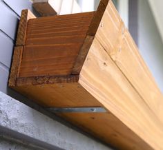 a close up of a wooden window sill on a house's outside wall