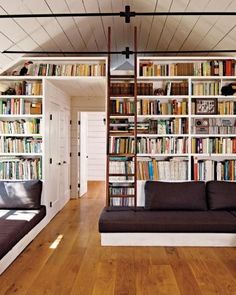 a living room filled with furniture and bookshelves next to each other on top of wooden floors