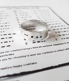 a silver ring sitting on top of a piece of paper