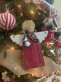 an angel ornament hanging from the top of a christmas tree