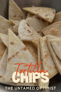 tortilla chips in a metal bowl with the words, the untamped optimist