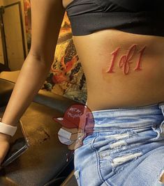 a woman's stomach with the number 11 on it and her name written in red ink