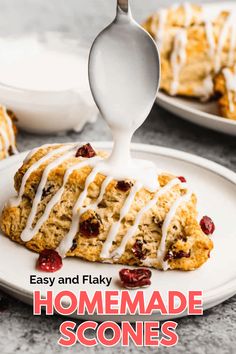 a white plate topped with scones covered in icing and cranberry sauce