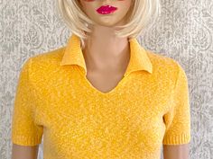 Vintage 70s knit light short sleeve sweater with 3" ribbed collar and rounded V neck.  It's  nice and soft to the touch and fabric has stretch.  The color is bright yellow that has a tin of tangerine and flecks of white.  It's definitely yellow, just want you to have a sense of what yellow as the photos don't show the exact hue. Mannequin is 32-24-34 Visit Our Shop https://www.etsy.com/shop/MirrorballBoutique LABEL: Too faded to read MATERIAL: NA COLOR: Orangy Yellow SIZE/FIT: NA, see below ARMP 70s Sweater, Short Sleeve Knit Top, Pastel Sky, Ribbed Shirt, Yellow Short, Blue Crew, Yellow Shorts, Pullover Sweater Women, Short Sleeved Sweaters