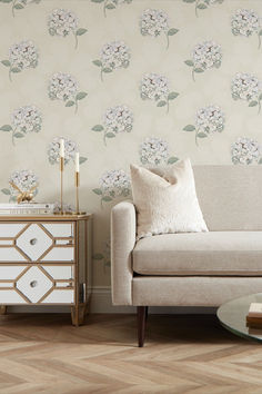 a living room scene with focus on the sofa and wallpaper that looks like flowers