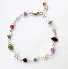 Can't decide on a gemstone: these bracelets have them all! A dainty semi precious stone bracelet with delicately hand wire wrapped stones in varied shapes and stones. Each bracelet is completely unique and one of a kind with a colorful array of stones including garnet, blue topaz, moonstone, pearl, quartz, tourmaline and many others. Strung on sterling silver wire and finished with a sterling silver lobster clasp. Adjustable Multicolor Sterling Silver Bracelet With Natural Stones, Multicolor Gemstone Beads Sterling Silver Bracelets, Multicolor Gemstone Beads Bracelet In Sterling Silver, Multicolor Sterling Silver Gemstone Bead Bracelets, Dainty Multicolor Gemstone Beads Bracelets, Dainty Multicolor Gemstone Bracelet, Adjustable Multicolor Bracelets With Gemstone Accents, Adjustable Multicolor Gemstone Bracelets, Wire Wrapped Stones