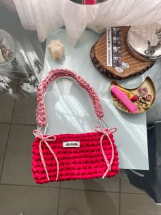 a red purse sitting on top of a white table next to other items and decorations