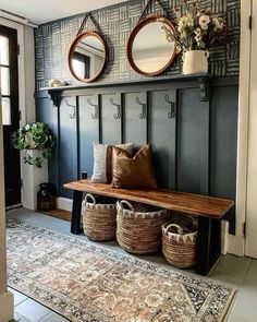 a bench with two mirrors above it and some baskets on the floor next to it