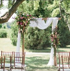 an outdoor wedding setup with white drapes and flowers